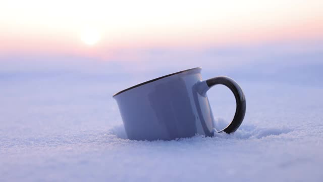 在寒冷的冬天，把热水瓶里的茶倒进杯子里视频素材