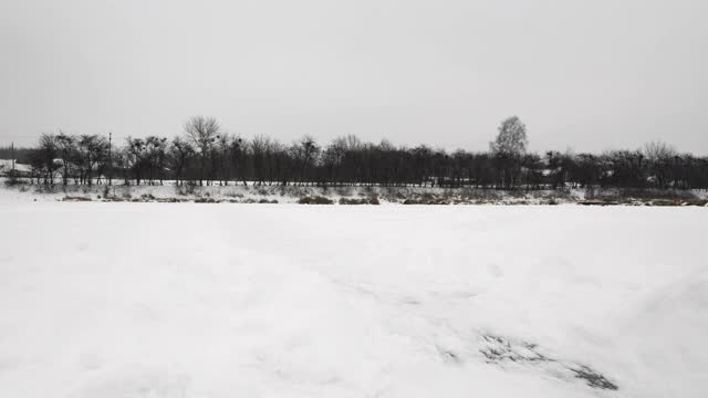 人类正在厚厚的冰面上滑冰。穿着花样滑冰鞋的男子在结冰的湖面上滑行。溜冰者在河面结冰的冰面上溜冰。冬季运动活动视频素材