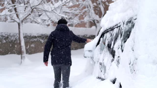 一名男子清理汽车附近的积雪视频素材