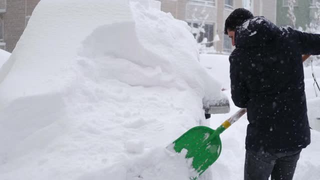 一名男子清理汽车附近的积雪视频素材