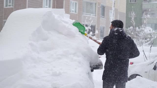 一名男子清理汽车附近的积雪视频素材