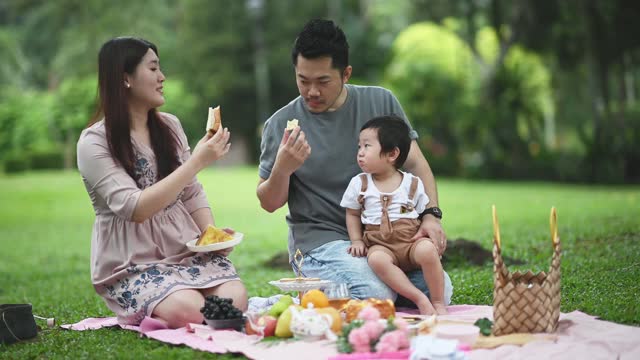 亚洲华人青年家庭享受户外野餐时间在周末视频素材