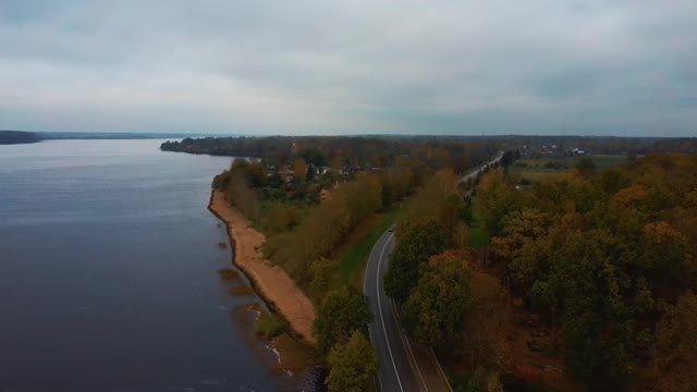 在拉脱维亚的多加瓦河的彩色森林和交通道路鸟瞰图。秋天的风景。视频素材