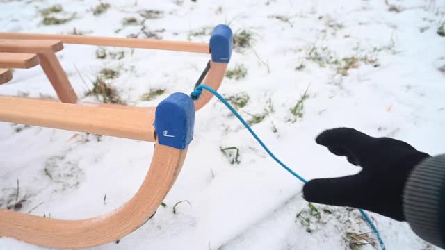 一个人驾驶一个木制的雪橇在冬天在雪地上。视频素材