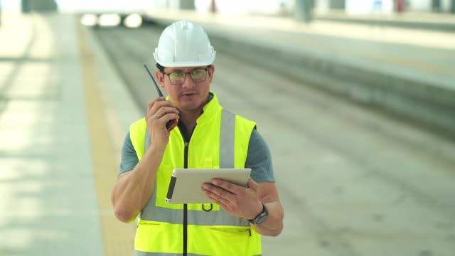 男技术工程师走过一个大型现代化火车站，商业、工业、旅游、现代化的服务站视频素材