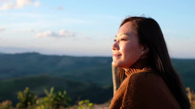 一个年轻的女旅行者看日出和美丽的绿色山景视频素材