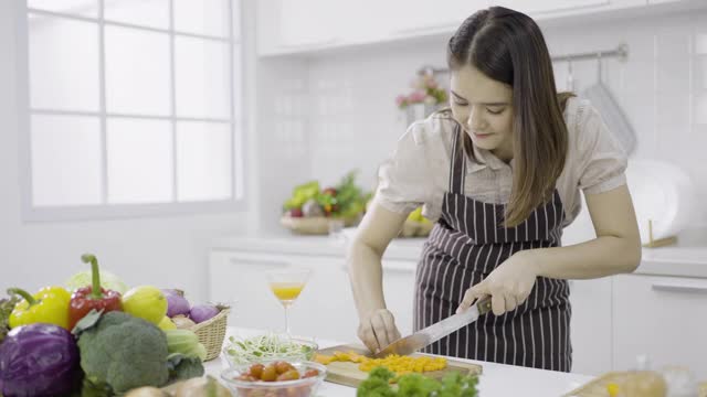 年轻女子用刀切胡萝卜视频素材