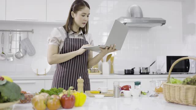 在厨房里用笔记本电脑的女人视频素材