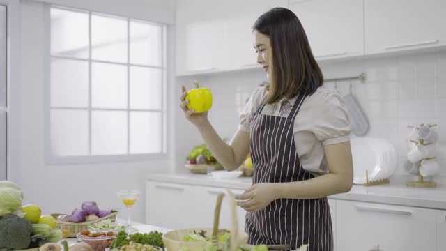 穿着围裙的年轻女子扔着黄色的甜椒视频素材