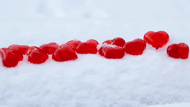 小红心玻璃上的粉状雪花在冬日里，浪漫的爱情，圣瓦伦丁节的节日概念视频素材