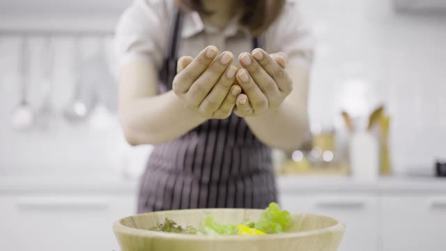 女人把整个圣女果扔进木碗里视频素材