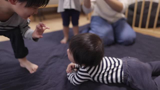 年轻的家庭和三个孩子一起在客厅里玩耍视频素材