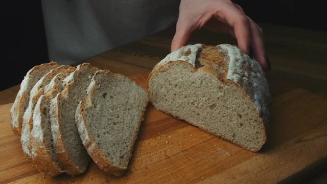 在厨房切面包的女人。把面包切片做三明治。烹饪过程视频素材