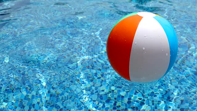 游泳池里的沙滩球。彩色充气球漂浮在游泳池。视频素材