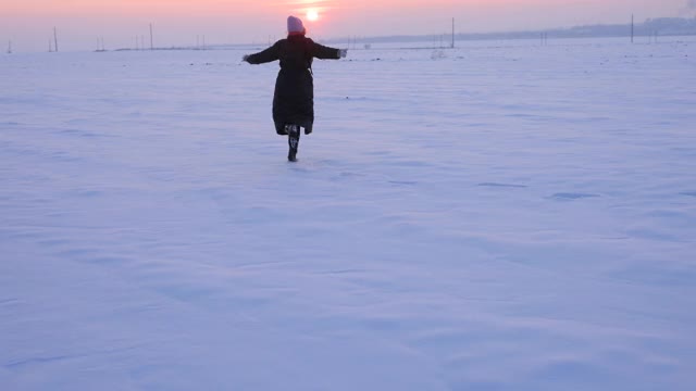 在白雪覆盖的北极雪地上奔跑的女人视频素材