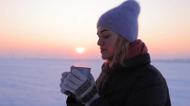 一个女人在一个寒冷的冬天喝着一杯茶视频素材