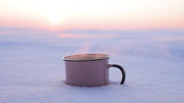 在下雪天把热水瓶里的茶倒进杯子里视频素材