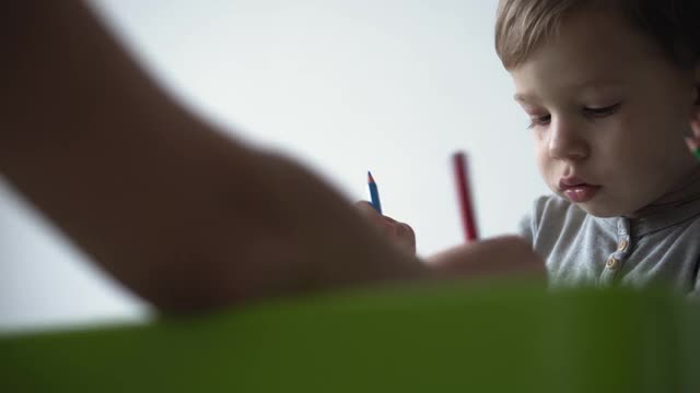 童年，艺术，教育，创造力，母亲的概念-真实的年轻妈妈和两个孩子学前创造性的天才孩子男孩2-4岁和婴儿婴儿画画笔画坐在桌子上视频素材