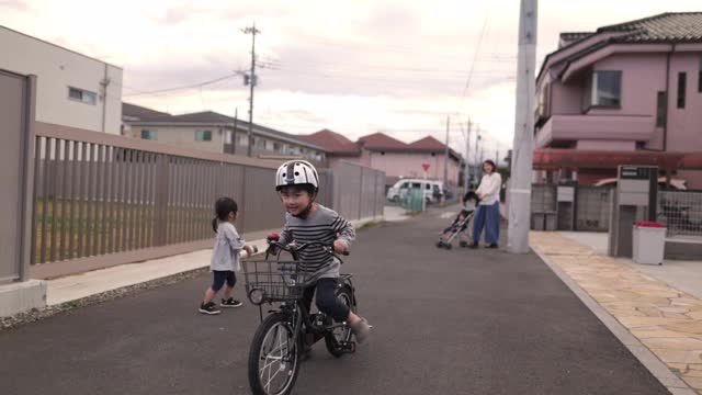 小男孩在街上练习骑自行车视频素材