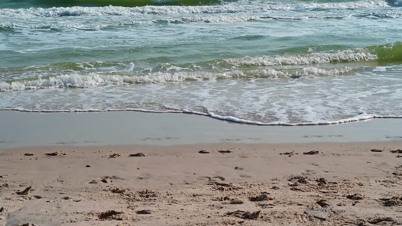 柔软的海浪和蓝色的海洋在沙滩上。视频素材