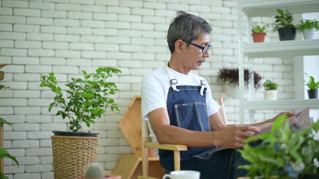 一位老人正在家中边喝咖啡边看报纸视频素材