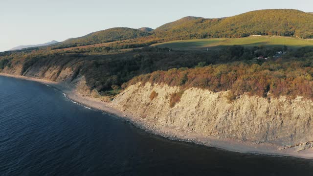 鸟瞰碧海碧水，石崖石壁，以青山绿林为背景，美丽自然自由的景观理念视频素材