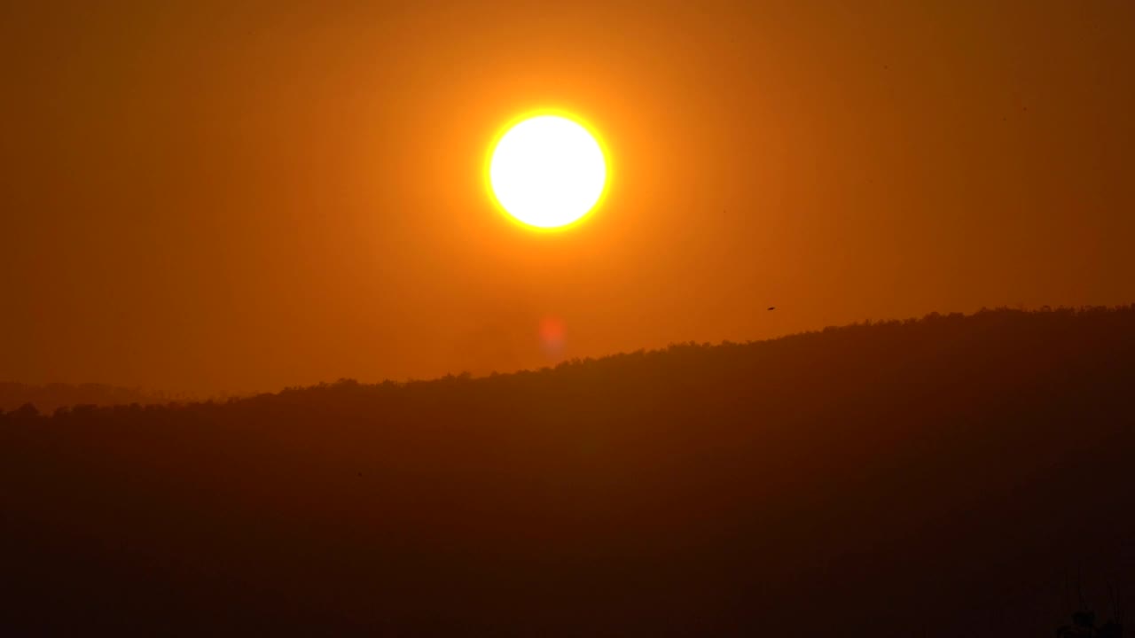 金色的日落在黑暗的山和天空的背景，鸟瞰图的太阳上剪影墙纸，关闭美丽的阳光光线在农村视频素材