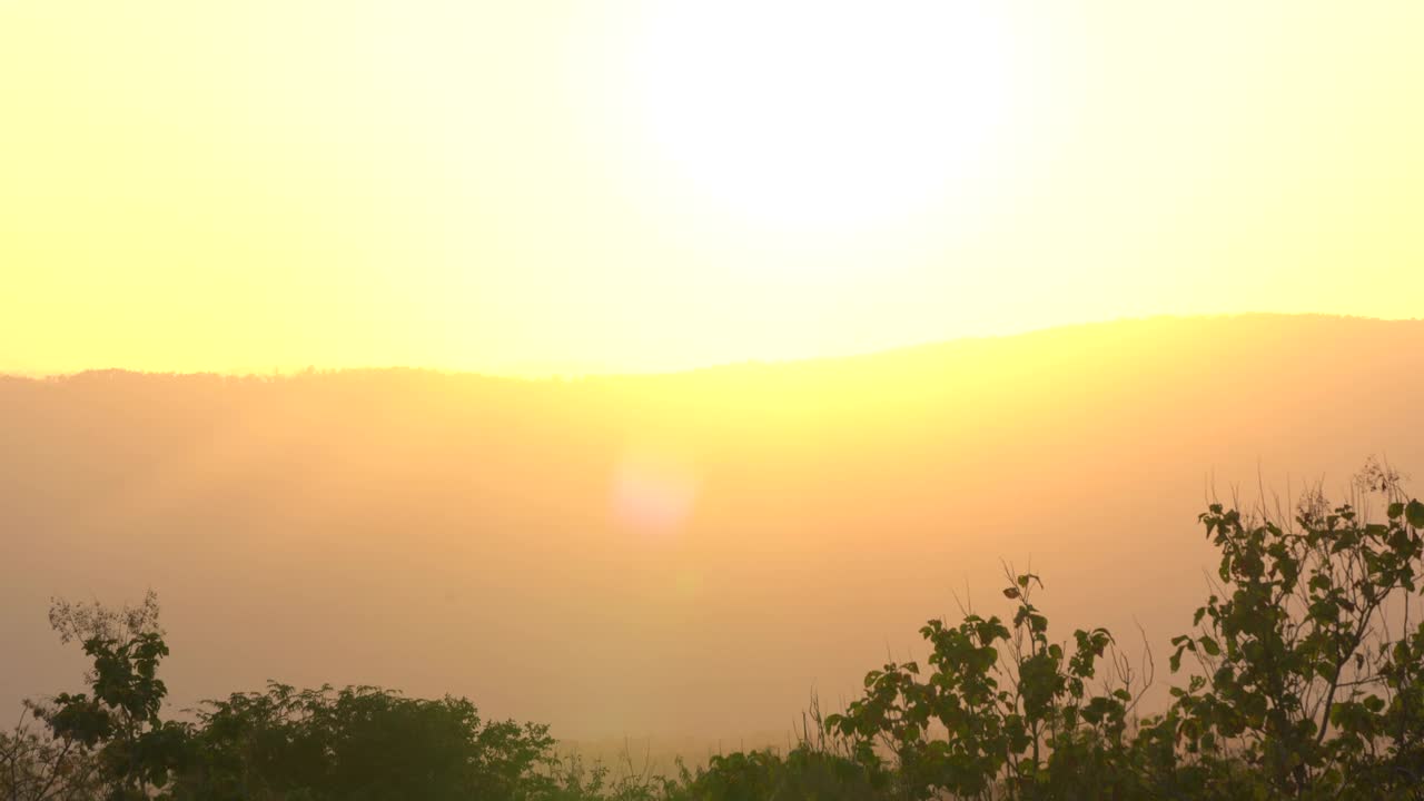 金色的日落在黑暗的山和天空的背景，鸟瞰图的太阳上剪影墙纸，关闭美丽的阳光光线在农村视频素材