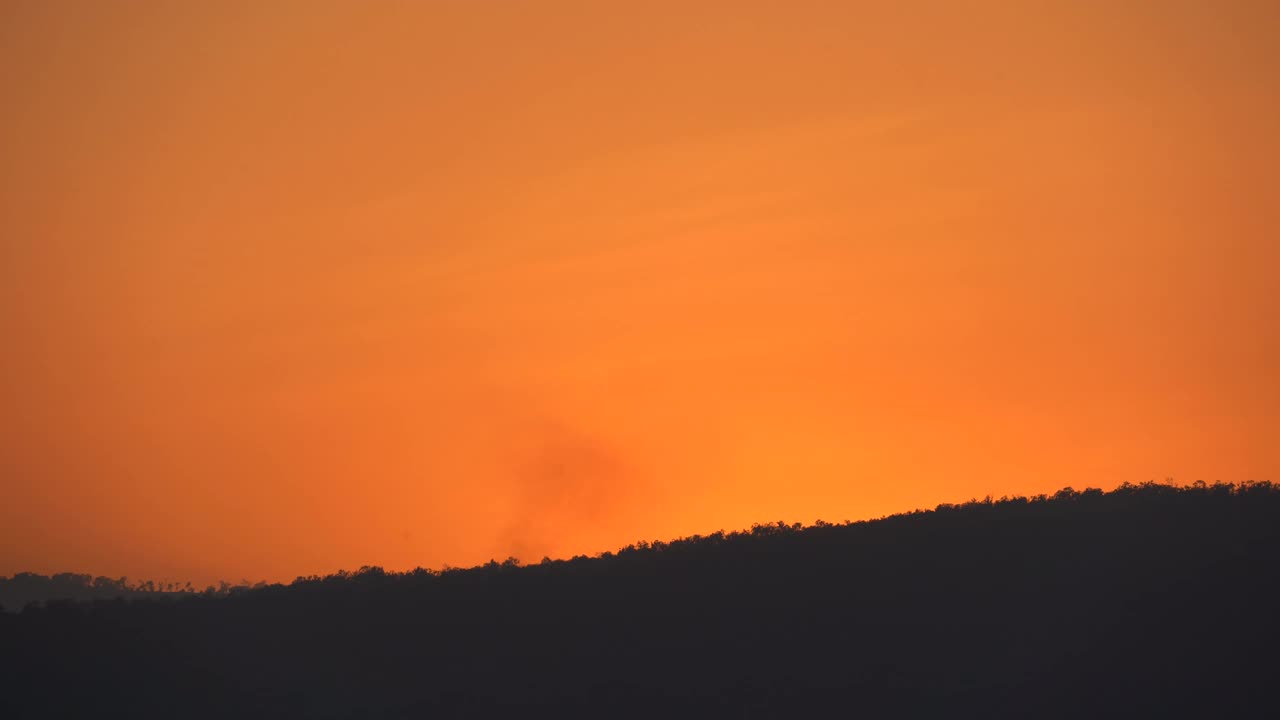 金色的日落在黑暗的山和天空的背景，鸟瞰图的太阳上剪影墙纸，关闭美丽的阳光光线在农村视频素材