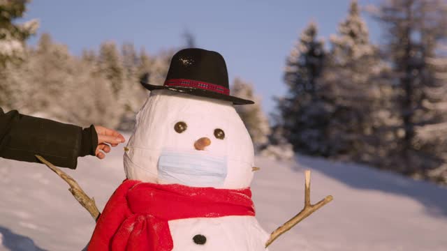 特写:一个面目全非的女人摘下了一个滑稽的雪人的外科口罩。视频素材