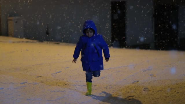 学前班的男孩晚上在雪地里玩。视频素材