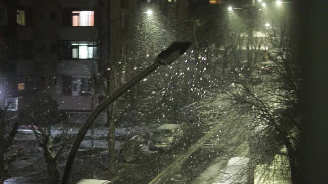 美丽的冬季景观与飘落的雪。城市的冬夜视频素材