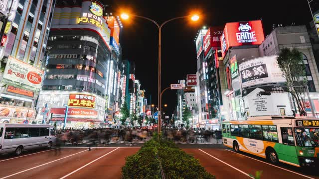 时光流逝的汽车交通运输，拥挤的亚洲人在日本新宿歌舞伎町的夜晚过马路。日本的夜生活文化，东京的地标性旅游景点，或交通概念视频素材