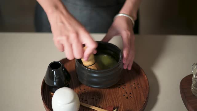 女人用竹打蛋器泡抹茶视频素材