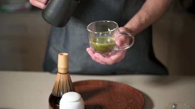 男人用牛奶泡制作抹茶绿茶拿铁视频素材