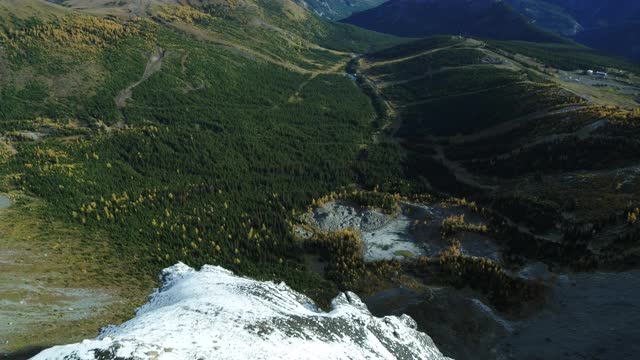 无人机飞越雪山边缘向下看岩石面视频素材