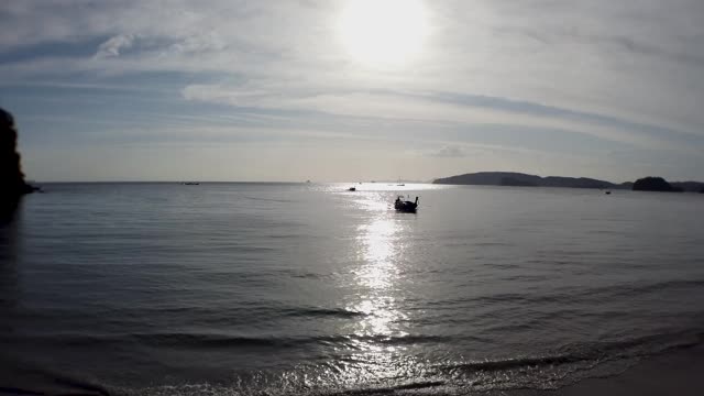 泰国Krabi Ao Nang海滩美丽的海滩，夕阳西下时，长尾船驶回海滩前。视频素材