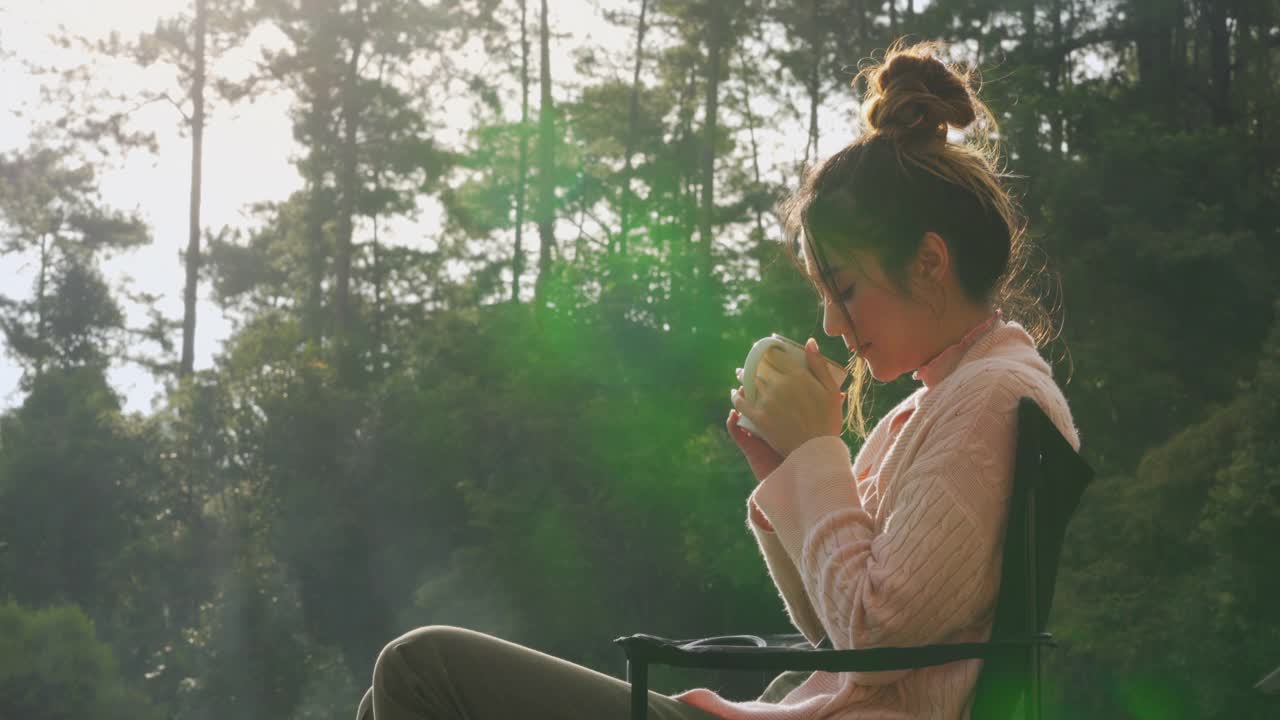 亚洲女人坐在阳台上喝着一杯热咖啡在早上视频素材