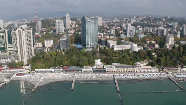 城市海滩，海滨，度假摩天大楼景观。现代度假城市与玻璃高层酒店在海岸从无人机上。4 k鸟瞰图视频素材