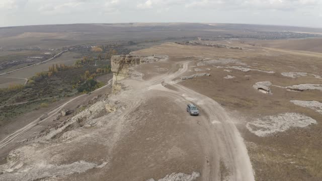 从无人机上俯瞰高原的Suv汽车。越野车辆行驶在土路，而极端旅行在山区地形。空中后视图4k视频素材