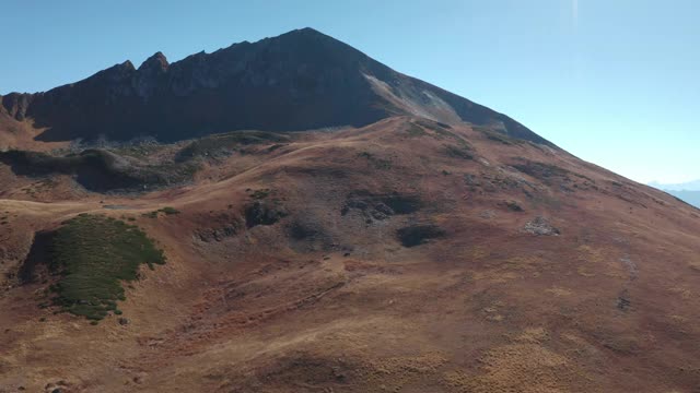 令人惊叹的空中景观，高山平原和高地上的田野和天空背景。美丽的野生高峰晴天在山区地形，草原和高原周围的自然无人机观看4k视频素材