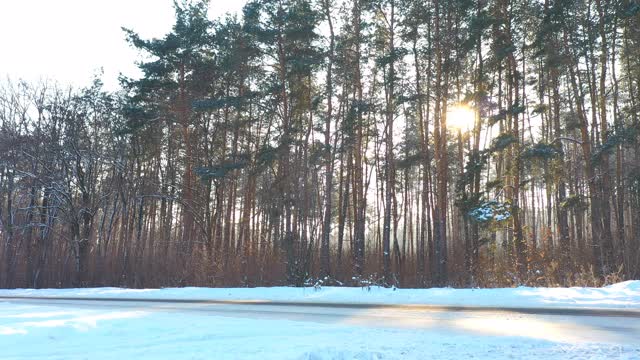 白色的汽车在冰雪覆盖的道路上快速行驶。在晴朗的日子里，越野车行驶在空旷的乡村路线上。自动移动通过风景优美的景观方式。旅行的概念。俯视图无人机拍摄视频素材