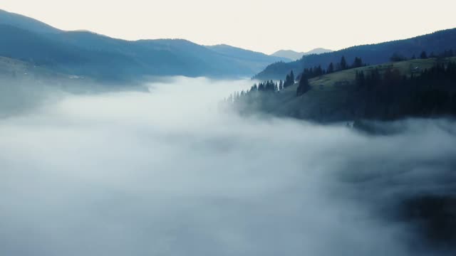 风景如画的鸟瞰图，浓雾覆盖山谷山间在傍晚在农村视频素材