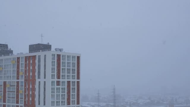 大片的雪花从天空飘落到摩天大楼的屋顶上视频素材