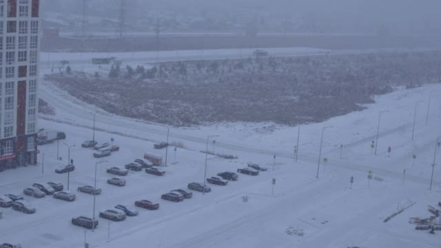 冬天的城市景观。城市里下起了暴风雪，大片雪花从空中飘落下来视频素材