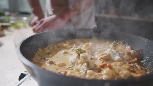 在热锅上加入香菜到奶油汁肉中视频素材