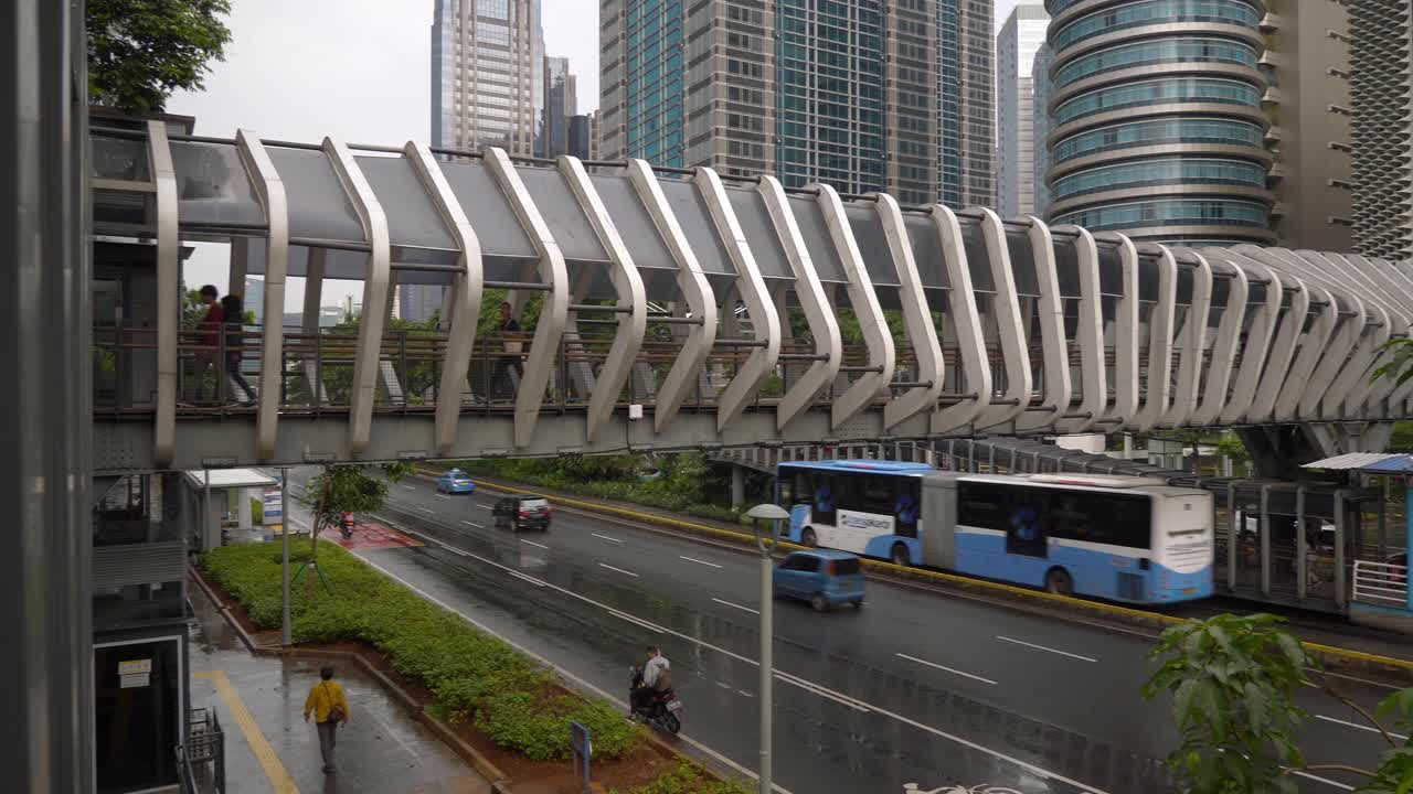 下雨天雅加达市区著名的人行天桥交通街道顶部慢镜头全景4k印尼视频素材