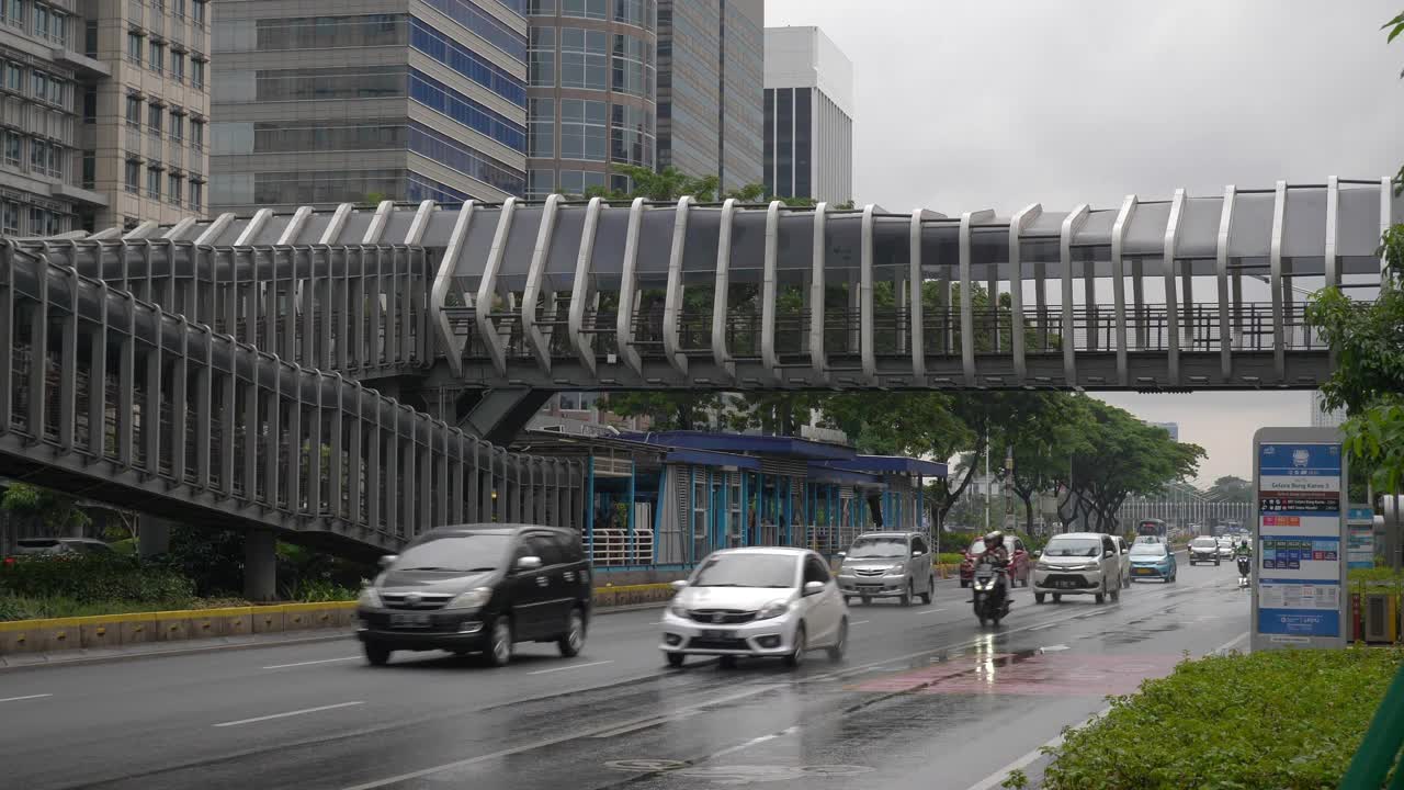 下雨天雅加达市区著名的人行天桥交通街道慢镜头全景4k印尼视频素材