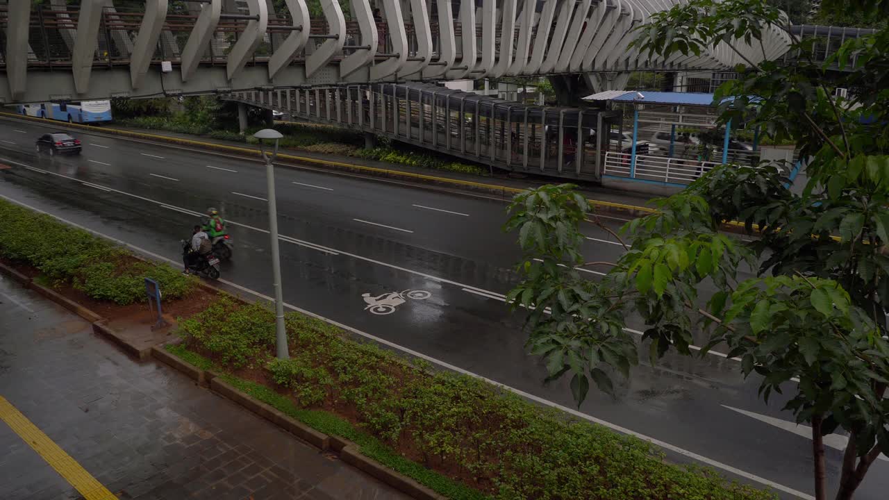 下雨天雅加达市区著名的人行天桥交通街道顶部慢镜头全景4k印尼视频素材