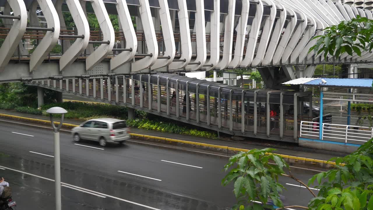 下雨天雅加达市区著名的人行天桥交通街道慢镜头全景4k印尼视频素材